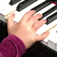 child's hand on piano